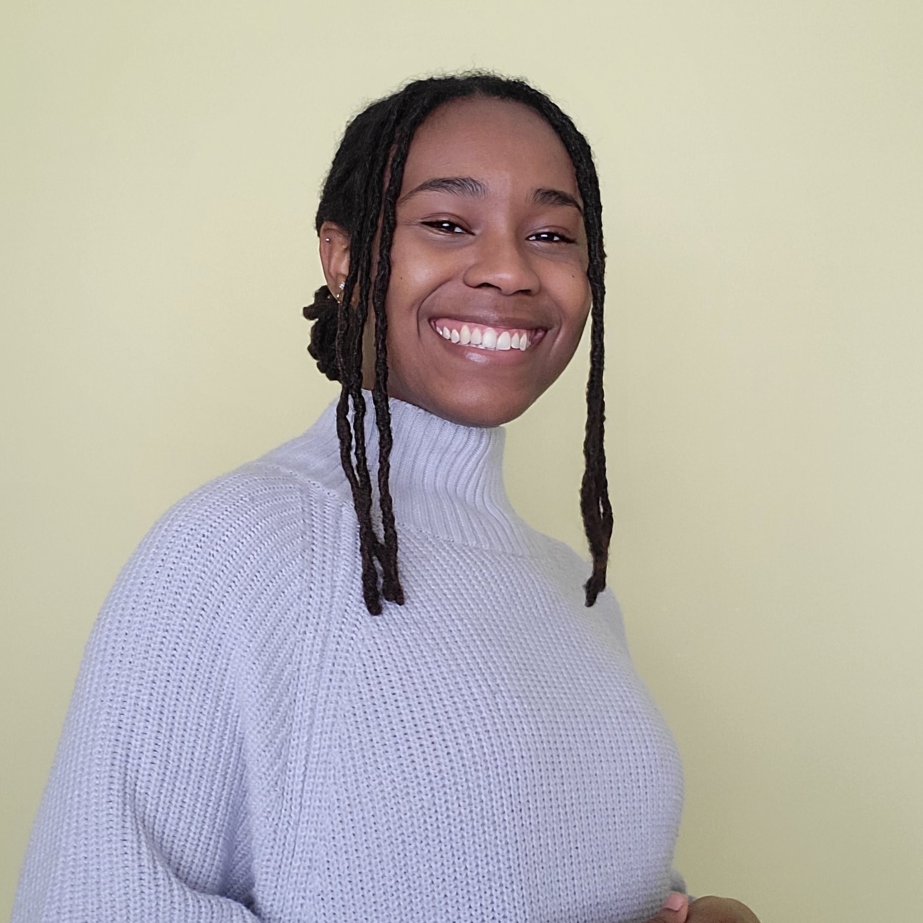 Janae Welsh smiling on a yellow backdrop